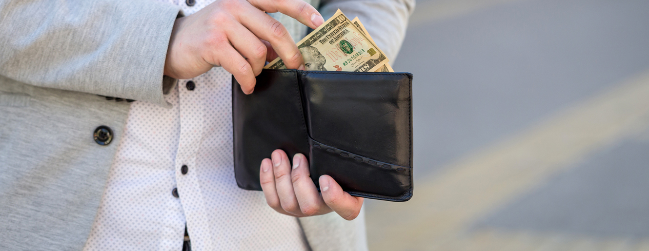 hand putting money in a wallet